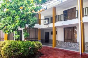 a courtyard of a building with a tree at Casa hotel las gaviotas II in Santa Marta