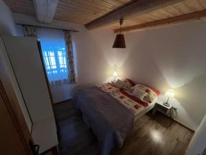 a bedroom with a bed with two lamps and a window at Penzión Skorušina in Brezovica