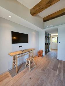a room with a wooden table and a tv on a wall at Villa prestige au bord de l'eau- Misincu in Cagnano