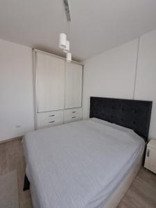 a bedroom with a large bed with a black headboard at Siena Cozy retreat with self check in in Popeşti-Leordeni