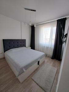 a bedroom with a large bed and a window at Siena Cozy retreat with self check in in Popeşti-Leordeni