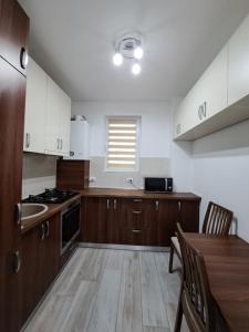 a kitchen with wooden cabinets and a wooden table with a tableablish at Siena Cozy retreat with self check in in Popeşti-Leordeni