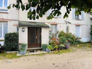 uma pequena casa com vasos de plantas em frente em Chaleureux appart, proche de La Loire avec parking em Orléans