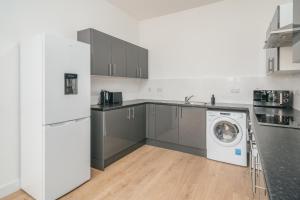 a kitchen with a washer and a washing machine at Contractors I Working professionals I Relocators - Near Train Station and Airport in Luton