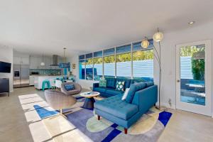 a living room with blue furniture and a kitchen at The Aluminum House Permit# 2227 in Palm Springs