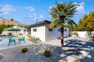 een huis met een palmboom en een tafel en stoelen bij The Aluminum House Permit# 2227 in Palm Springs