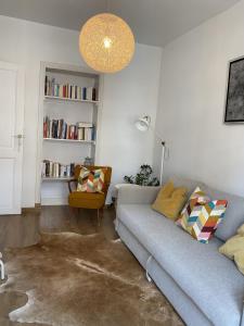 uma sala de estar com um sofá e uma cadeira em Rétro Studio em Bruxelas