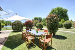 einen Tisch mit Stühlen und einen Regenschirm im Hof in der Unterkunft Agriturismo La Fattoria in Panicarola