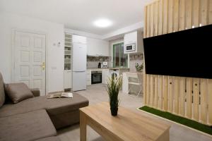 een woonkamer met een bank en een flatscreen-tv bij Casa David Prieto 2 Habitaciones in Caleta De Fuste