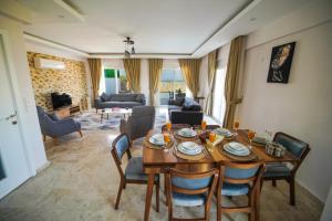 Villa Letoon 2 : غرفة معيشة مع طاولة وكراسي خشبية