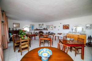 uma sala de jantar com mesas e cadeiras de madeira em Sweetposeidon em Ischia