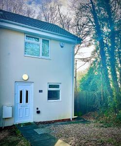 ヘメル・ヘムステッドにあるAbsolutely Beautiful Hemel Hempstead 2-bedroom for 1-5 Guests - contractors welcomeの青い扉と柵の白い家