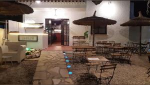 a restaurant with tables and chairs and umbrellas at SUNSET HOLIDAY RIUMAR in Riumar