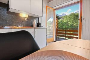 eine Küche mit einem Tisch und einem großen Fenster in der Unterkunft Charmant studio avec parking gratuit in Ovronnaz