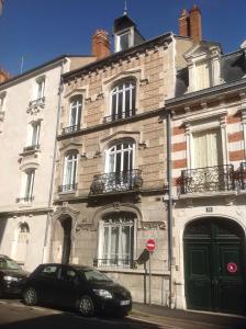 um edifício com dois carros estacionados em frente em Chez Eudoxe em Orléans