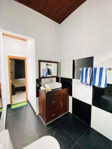 uma casa de banho com um lavatório e um espelho em Erin Orr Villa em Wadduwa