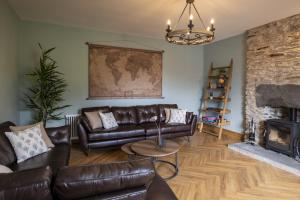a living room with leather furniture and a fireplace at Pen Isa’r Llan in Bala