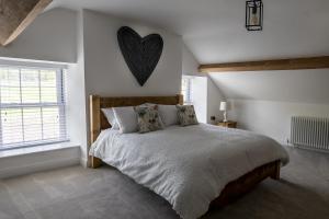 a bedroom with a bed with a heart on the wall at Pen Isa’r Llan in Bala