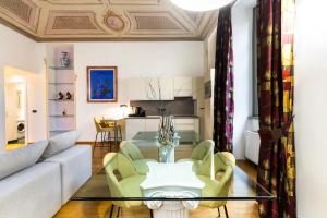 uma sala de estar com um sofá e uma mesa de vidro em Dimora Novecento [PORTA NUOVA-CENTRO] em Turim
