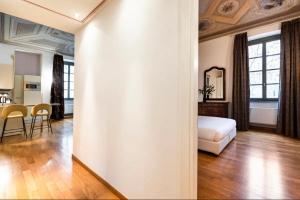 uma sala de estar com uma cama e uma sala de jantar em Dimora Novecento [PORTA NUOVA-CENTRO] em Turim
