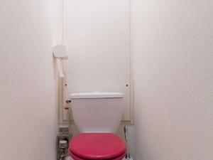 Appartement Briançon, 1 pièce, 4 personnes - FR-1-330C-49 في بريانسو: مرحاض أبيض مع غطاء احمر في الحمام