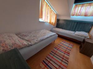 een slaapkamer met 2 bedden en een tapijt bij Krisztina-Rózsa ház in Balatonföldvár