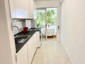 a kitchen with white cabinets and black counter tops at Charming 3 Bedroom Apartment in the centre of Faro in Faro