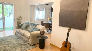 a living room with a guitar and a couch at Charming 3 Bedroom Apartment in the centre of Faro in Faro