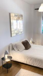 a white bed in a room with two tables at Charming 3 Bedroom Apartment in the centre of Faro in Faro