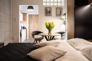 a bedroom with a bed and a table with flowers on it at Old Town Heart XII - Poznańska Luxury Loft in Warsaw