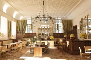 ein Restaurant mit Tischen, Stühlen und einem Kronleuchter in der Unterkunft Hôtel du Couvent, a Luxury Collection Hotel, Nice in Nizza
