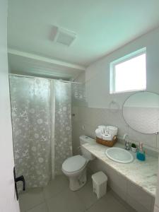 a bathroom with a toilet and a shower and a sink at Sam Day Suites in Natal