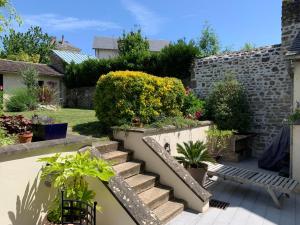 a garden with stairs and plants and a bench at La maison d'Hélios in Alençon