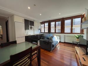 een keuken en woonkamer met een bank en een tafel bij Atuaire Home Luz de Burgos II Centro con Parking Incluido in Burgos