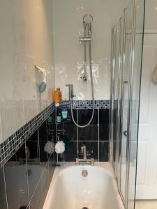 a bathroom with a bath tub and a shower at Central Poole spacious room in Edwardian house in Poole