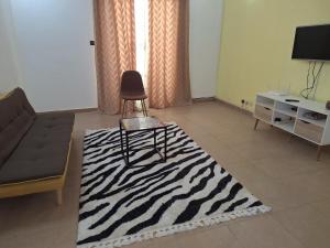 sala de estar con alfombra de cebra y silla en Studio spacieux, en Dakar