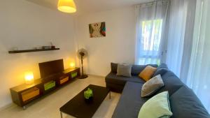 a living room with a blue couch and a tv at Apartamento en Pinar de la Cala - D in L'Ametlla de Mar