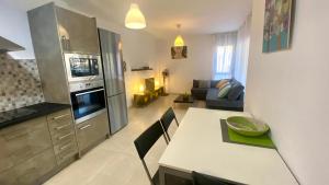 a kitchen and living room with a table and a couch at Apartamento en Pinar de la Cala - D in L'Ametlla de Mar