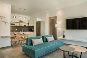 a living room with a blue couch and a kitchen at Villa Nefeli - Ionian Treasure Villas in Argostoli