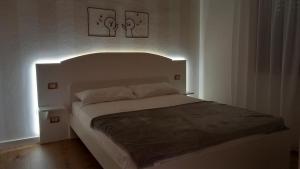 - une chambre avec un lit blanc et deux photos sur le mur dans l'établissement The Magic Place, à Quartu SantʼElena
