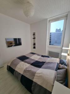 Un dormitorio con una cama grande y una ventana en Le Claussat - Hypercentre - Parking - Wifi, en Chamalières