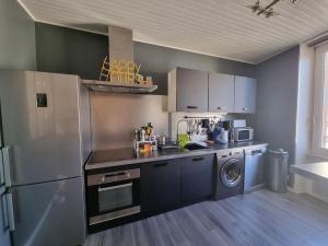 cocina con nevera y lavadora en Le Claussat - Hypercentre - Parking - Wifi, en Chamalières