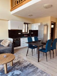 uma cozinha e sala de estar com mesa e cadeiras em Polar chalet em Kalívia
