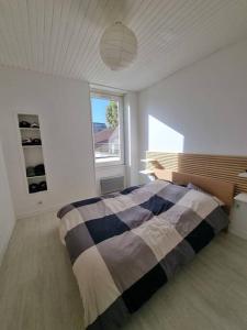 1 dormitorio con cama y ventana grande en Le Claussat - Hypercentre - Parking - Wifi, en Chamalières