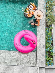 a person in a swimming pool with a pink flamingo in the water at Southern Peak Pool Villa Huay Yai Pattaya in Ban Huai Yai