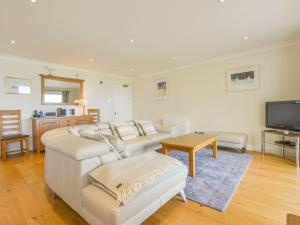 a living room with two white couches and a television at 19 Burgh Island Causeway in Kingsbridge