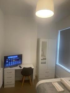 a bedroom with a desk with a computer and a bed at Orionn Place in Nottingham
