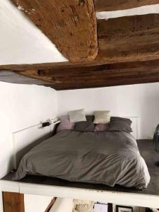 Łóżko w sypialni z drewnianym sufitem w obiekcie Studio charmant au cœur de Paris ! w Paryżu