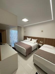 Un pat sau paturi într-o cameră la Hotel Jardim
