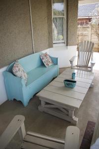 a blue couch and a wooden table and chairs at Tancredi B&B in Pietermaritzburg